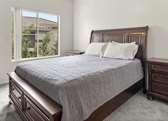 A bedroom with a large bed and a ceiling fan.