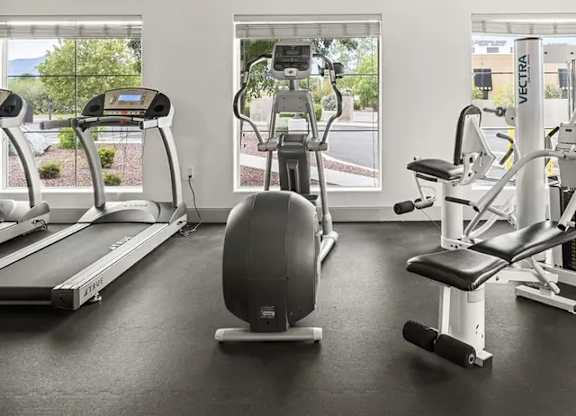 A gym with treadmills, elliptical machines, and other exercise equipment.