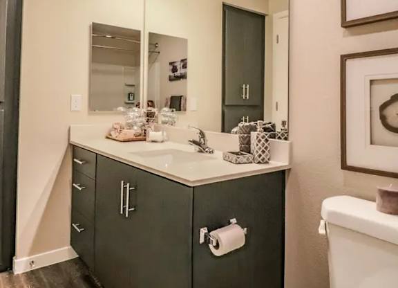 A bathroom with a vanity and a large mirror.