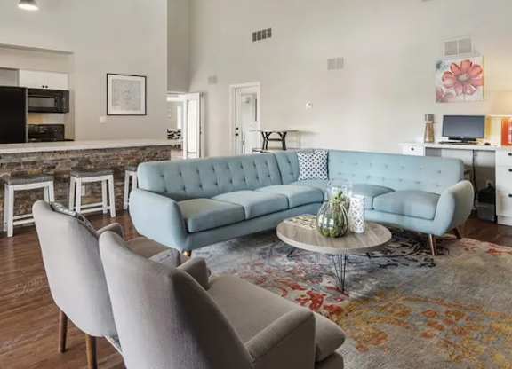 A living room with a blue couch and a ceiling fan.
