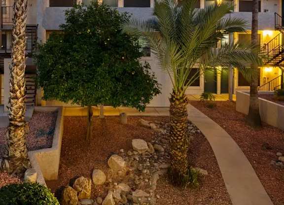 A building with a courtyard surrounded by palm trees.