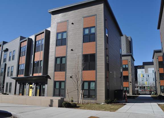 a new apartment building on the corner of a sidewalk