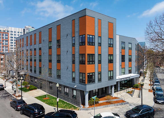 A modern building with orange and grey panels.