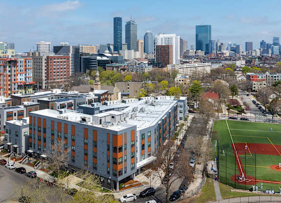 A cityscape with a baseball field in the foreground.