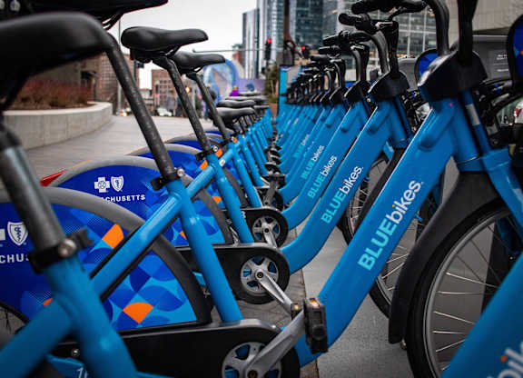 A row of blue bikes are parked next to each other.