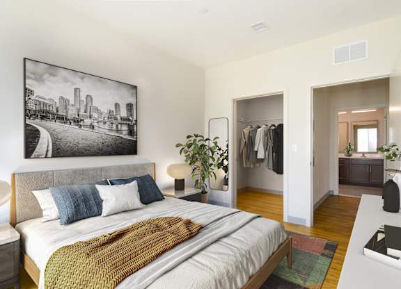 A bedroom with a large bed and a black and white photo on the wall.