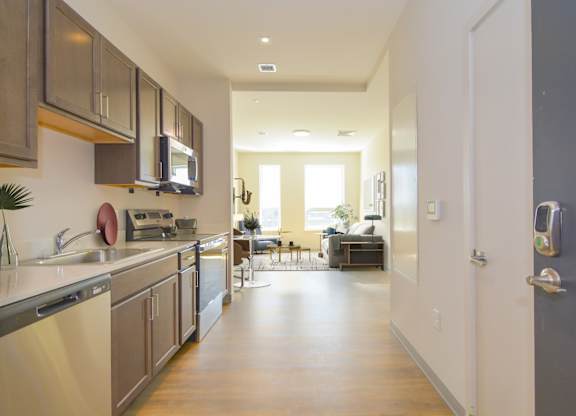 A modern kitchen with a dining area in the background.