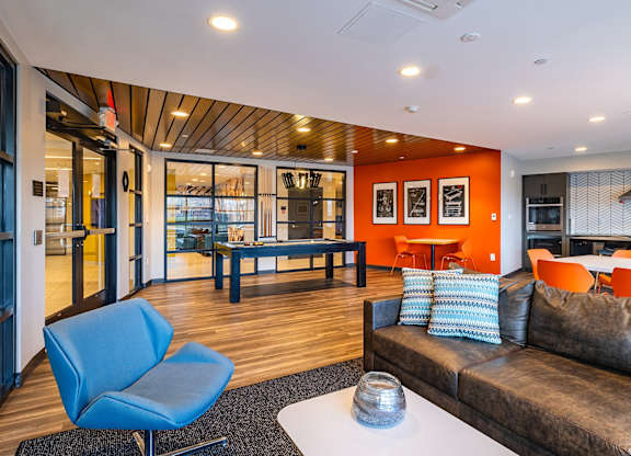A living room with a blue chair and a brown couch.