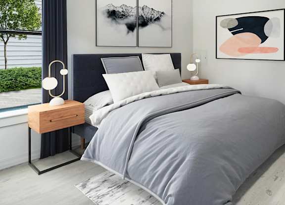 A bedroom with a large bed and two artworks on the wall.