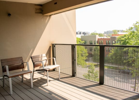 a balcony with two chairs and a view of the city