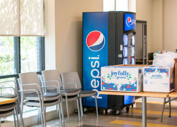 a vending machine in a room with chairs and tables