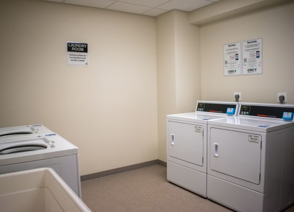 a laundry room with four washers and two dryers