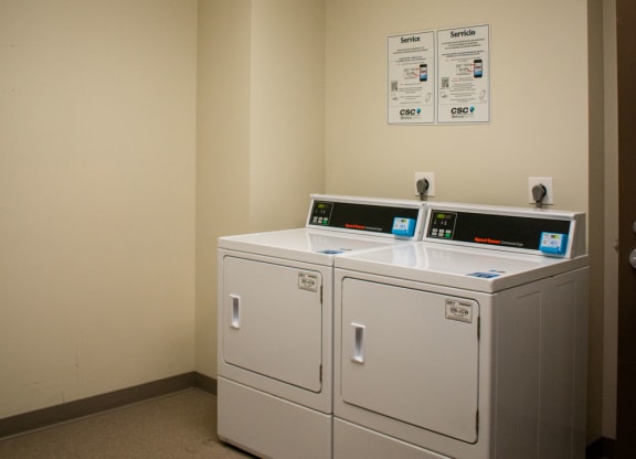 a room with two washers and two dryers