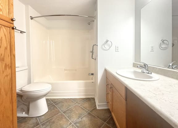 A bathroom with a toilet, sink, and shower.