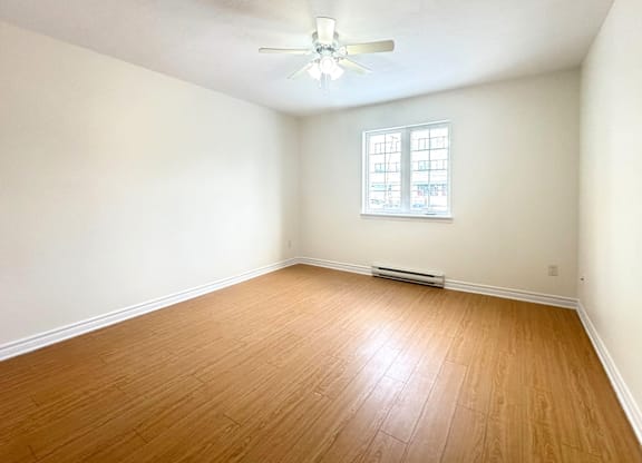 A room with a ceiling fan and a window.