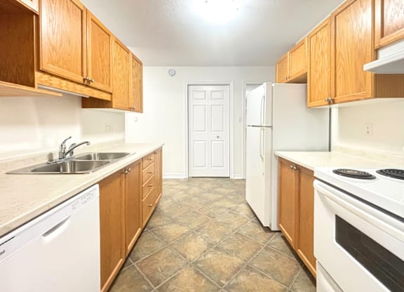 A kitchen with wooden cabinets and white appliances.