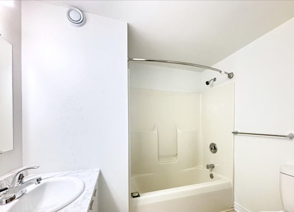 A white bathroom with a sink, toilet, and bathtub.