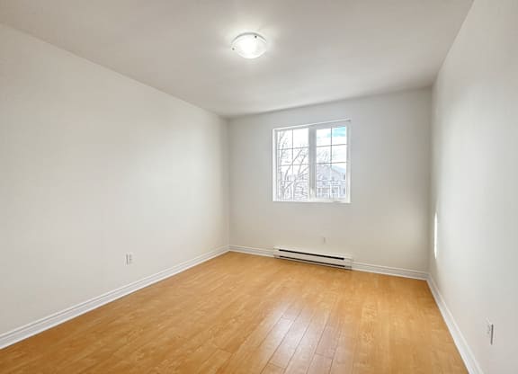 Empty room with wooden floor and a window.