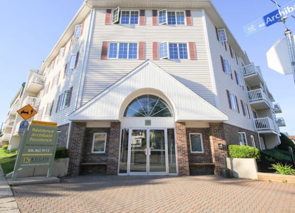 A large white building with a sign that says "Residence" in front of it.