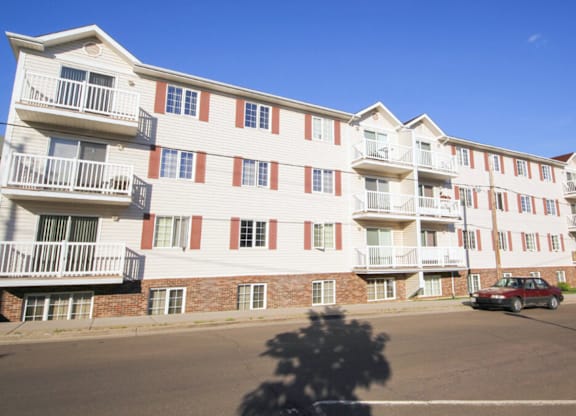 Apartment building with a car parked in front.