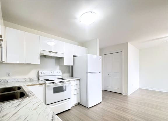A kitchen with white appliances and cabinets.