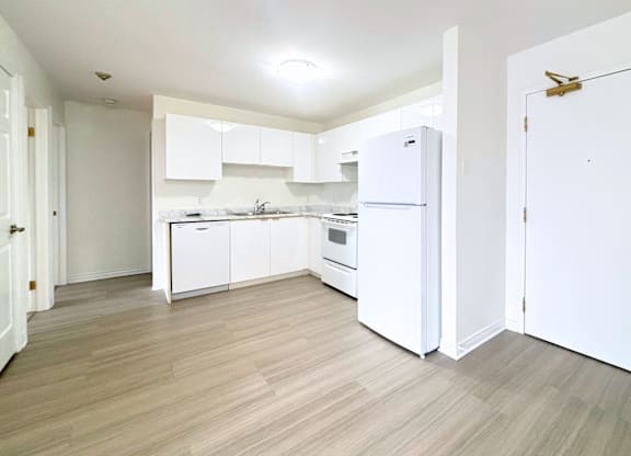 A kitchen with white appliances and cabinets.