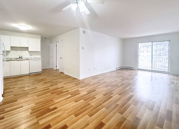 A room with wooden flooring and a ceiling fan.