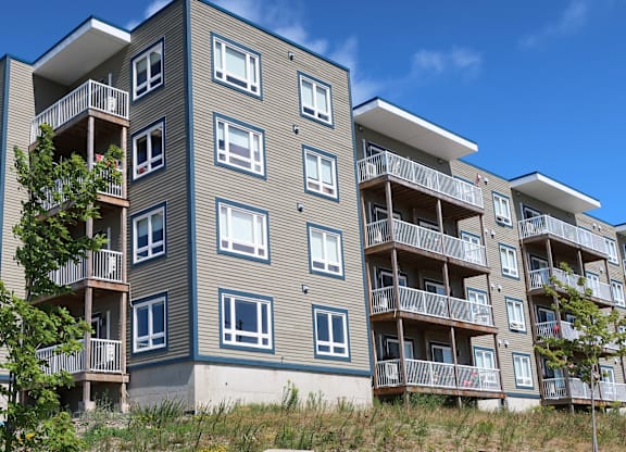A modern apartment building with balconies and windows.