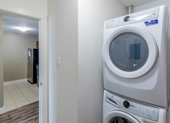 A white front loading washing machine in a laundry room.