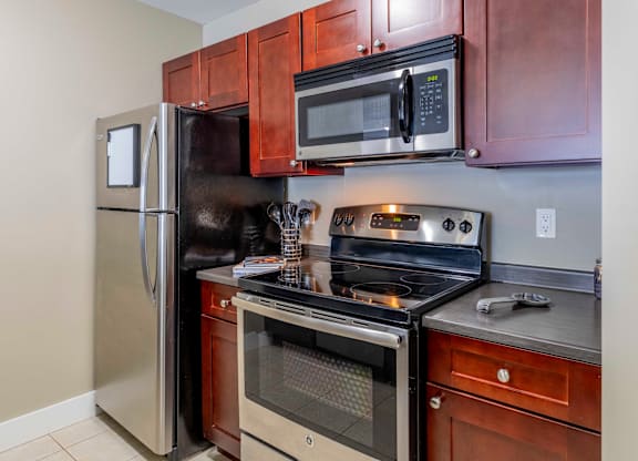 A kitchen with a refrigerator, oven, and microwave.