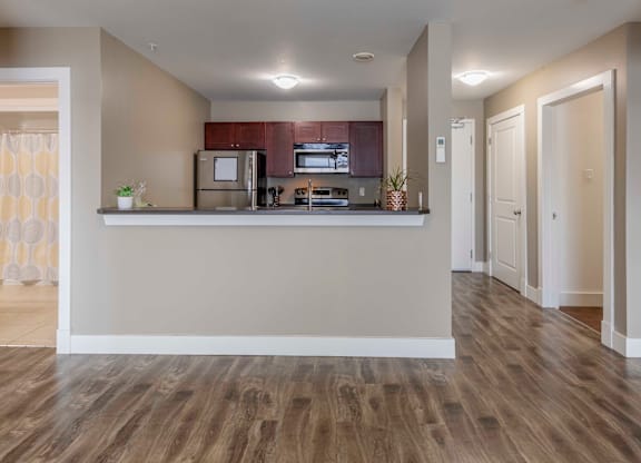 A kitchen with a refrigerator, microwave, and oven.