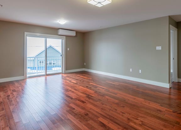 A room with wooden floors and a sliding glass door.