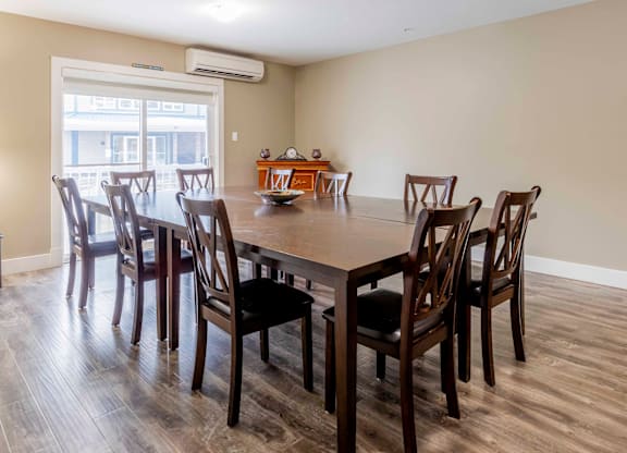 A dining room with a table and chairs.