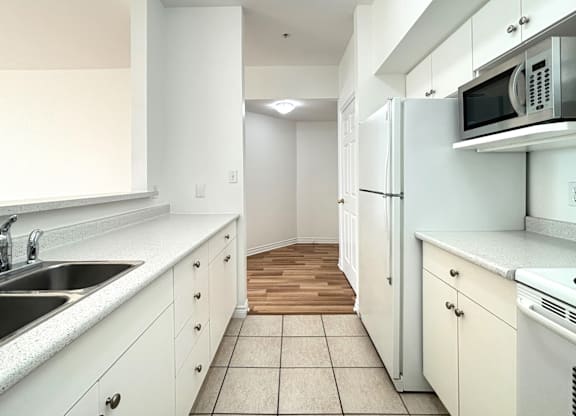 A kitchen with white cabinets and appliances.
