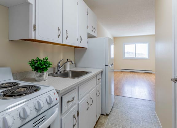 A kitchen with white cabinets and a stove top oven.