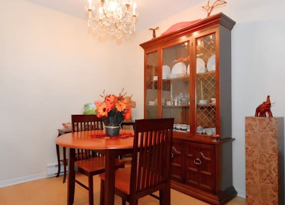 A wooden dining table with chairs and a chandelier in a room.