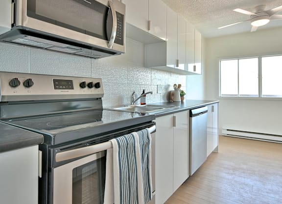 A modern kitchen with a stove top oven and microwave above it.