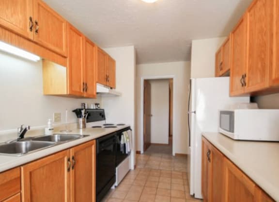 A kitchen with wooden cabinets and a white refrigerator.