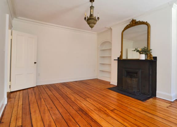 A room with a fireplace and a mirror.
