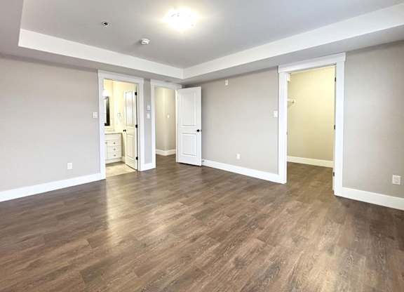 A room with wood flooring and white walls.