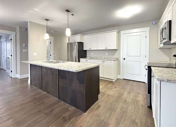 A kitchen with a white countertop and dark brown cabinets.