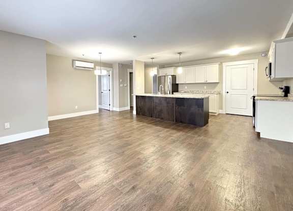 A kitchen with a dark countertop and white cabinets.