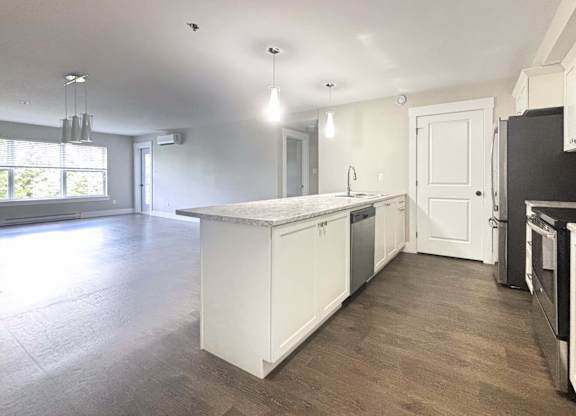 A kitchen with white cabinets and a large island in the middle.