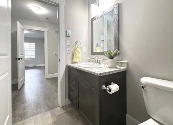 A bathroom with a sink, mirror, and toilet.
