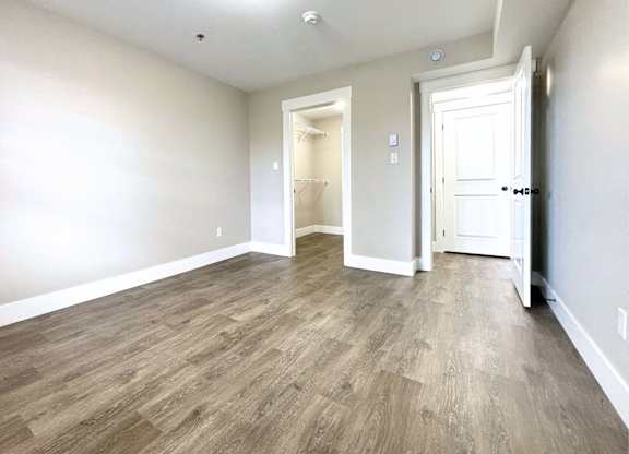 A room with wooden flooring and white walls.