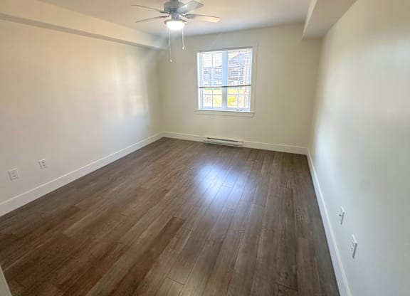 A room with a ceiling fan and a window.
