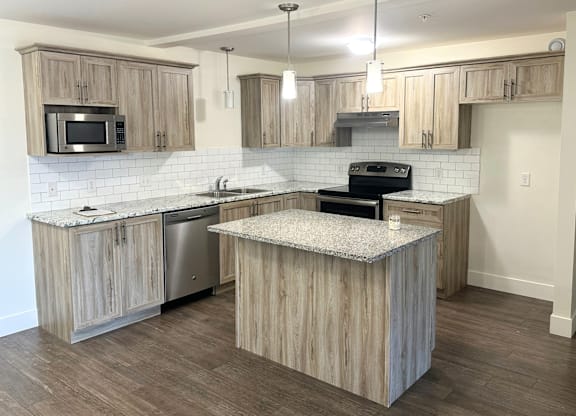 A kitchen with wooden cabinets and a granite countertop.