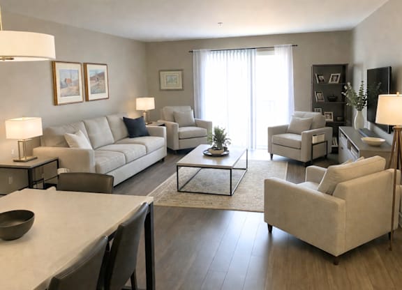 A living room with a white couch, a coffee table, and a television.