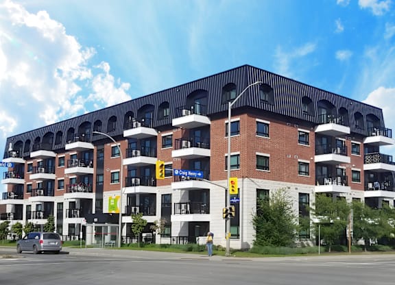 A large red brick building with a black roof and balconies.