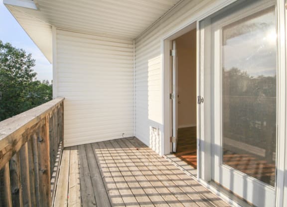 A white screened porch with a wooden railing.